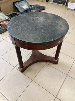 une table avec un plateau en marbre noir dans un magasin