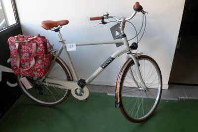 un vélo blanc avec un sac rouge à l'arrière