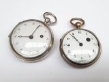 deux montres de poche en argent posées côte à côte sur une surface blanche