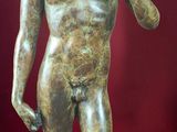 statue d'un homme tenant un serpent dans la main, sur fond rouge