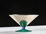 a martini glass sitting on a table with a green base