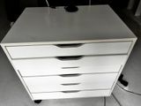 une commode blanche sur laquelle est posé un ordinateur