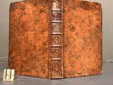 an old book with a brown cover sitting on top of a table