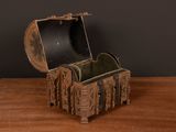 a small wooden box on a table with a black wall in the background