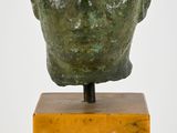 an image of a sculpture of a man ' s head on a wooden stand