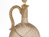 a glass bottle with a gold decoration on it