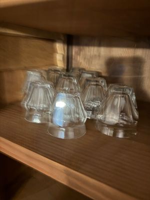 a lot of glasses sitting on a shelf in a room