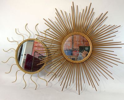 a mirror and a sunburst hanging on the wall