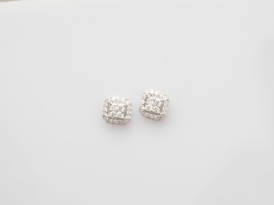 a pair of diamond earrings on a white surface
