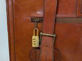 brown leather briefcase with a lock on the handle
