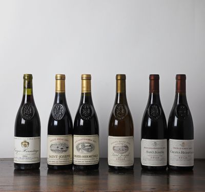 plusieurs bouteilles de vin sont alignées sur une table en bois