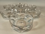 a glass bowl with six small bowls in it on a table