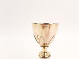 a gold cup sitting on top of a white table