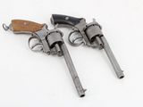 two old revolvers sitting on top of each other on a white surface