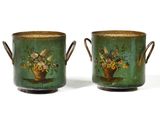 pair of green vases with flowers on them sitting on a table