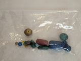 a plastic bag filled with stones and beads on a table