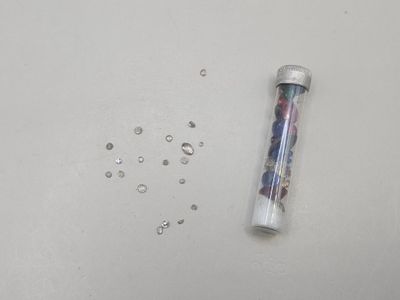 an image of a bottle of water and some beads on a table