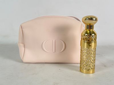 pink purse with a gold perfume bottle next to it on a white surface