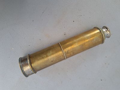 un petit objet en laiton posé sur une surface blanche