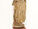 statue of a woman holding a child on a wooden stand
