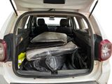 the back of a white car with a bunch of luggage in the trunk