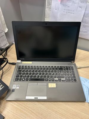 un ordinateur portable posé sur un bureau à côté d'un téléphone