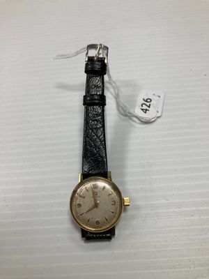 gros plan d'une montre sur une surface blanche avec une étiquette de prix