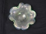 a glass flower shaped object on a black surface