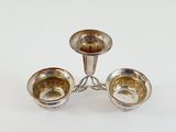 three silver plated candlesticks on a stand on a white background