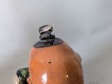 a small ceramic figurine of a man with a hat on his head