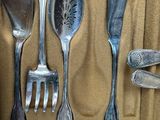 a lot of silver spoons and forks in a box