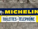 a sign that says michel toilettes telephone on the side of a building