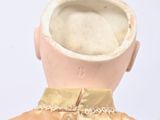a doll with a gold dress and a white hat