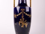 un vase bleu orné d'une décoration dorée