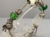 un bracelet transparent orné d'une perle verte et d'une perle blanche