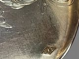 a silver plate with a bird on it on a table