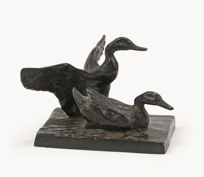 a statue of two ducks sitting on a marble block