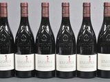 six bottles of wine are lined up in a row on a table