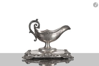 un plat ancien en argent orné d'un oiseau, posé sur un socle