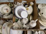 beaucoup d'assiettes et de bols dans des cartons posés par terre