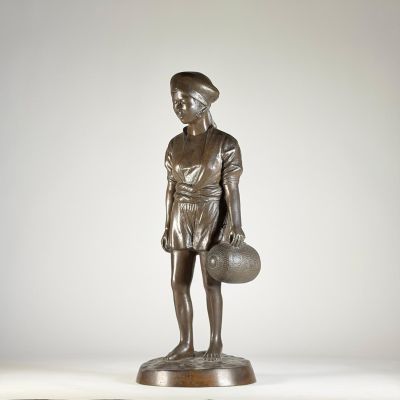 statue en bronze représentant un garçon tenant un ballon de basket, posée sur un socle en bois