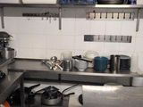 many pots and pans on the counter in this kitchen