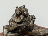bronze sculpture of a man and a woman on a wooden base