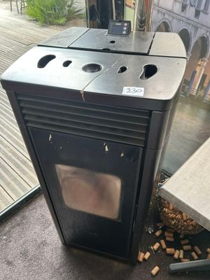 un poêle noir posé à même le sol près d'une fenêtre
