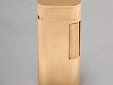 gold lighter sitting on top of a white surface on a table