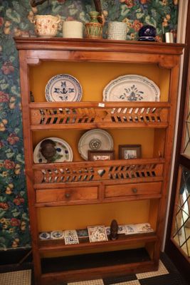 une étagère en bois sur laquelle sont posées des assiettes, dans une pièce