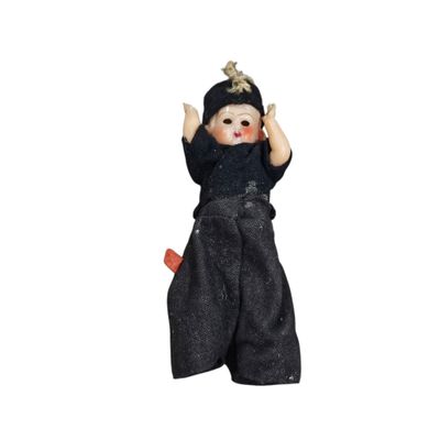 doll with black outfit and hat on a white background