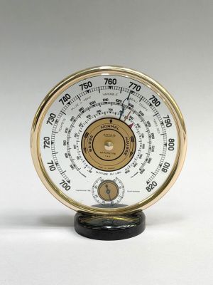 a close up of a clock on a white surface