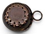 a close up of a pocket watch on a white surface