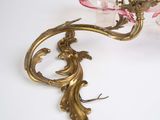 a gold candle holder with a pink flower on it